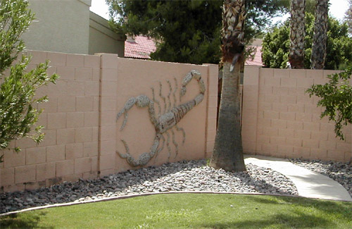 ciinderblock fence with a stone mosaic scorpion.